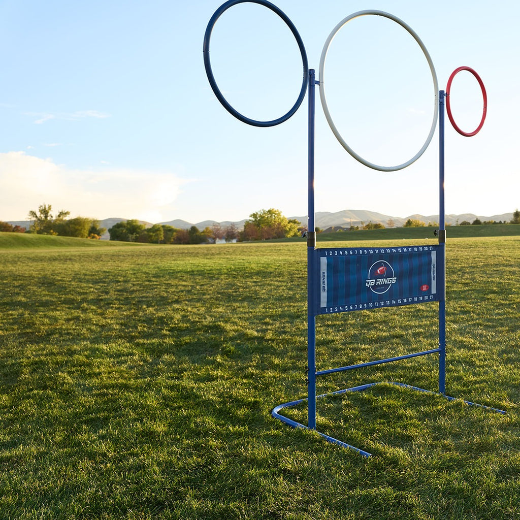 QB Rings game set up at full height on a grass field: blue, white and red rings above the yard-line banner